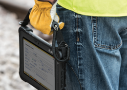 terminal de captura de datos colgando de mano de operario con guante amarillo